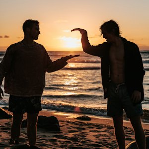 Dwie osoby na plaży o zachodzie słońca